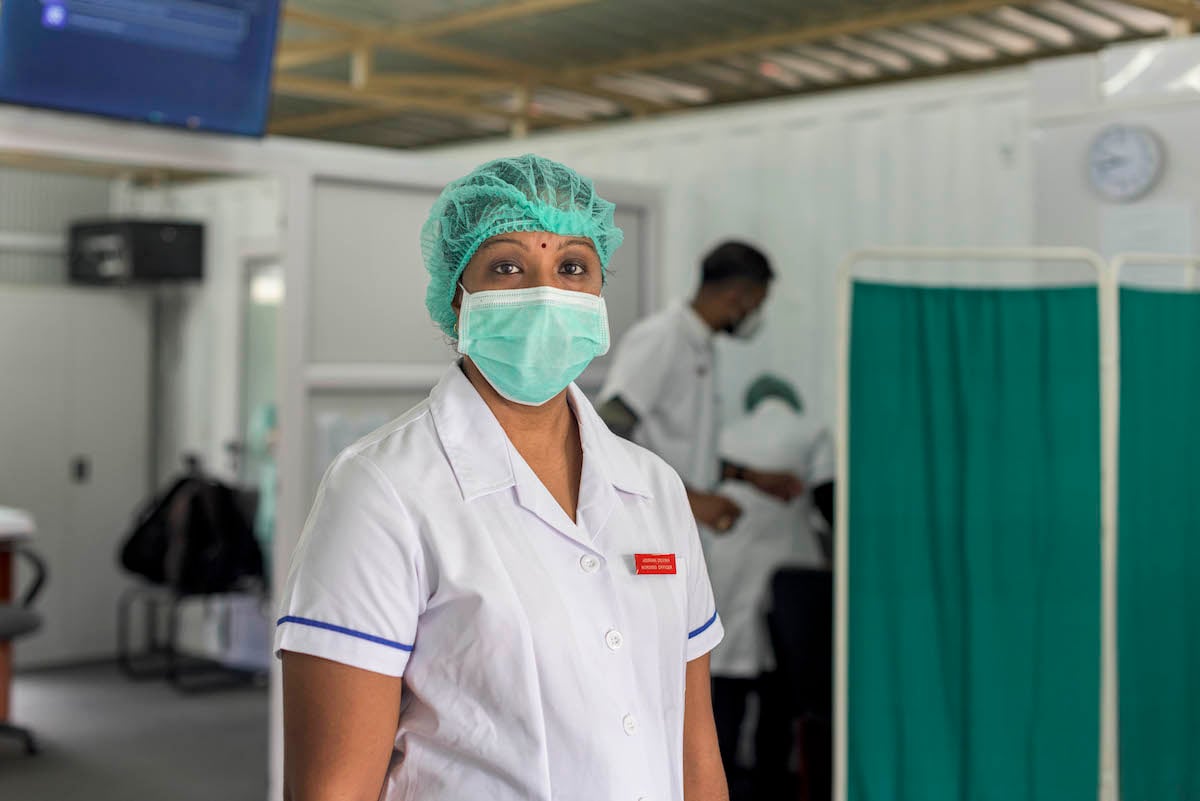 Female health worker in medical mask and haircover